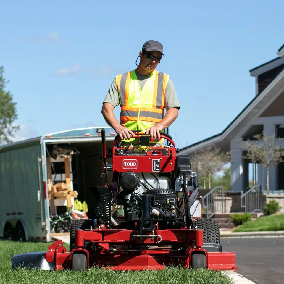 Red Toro stand-on mower being operated