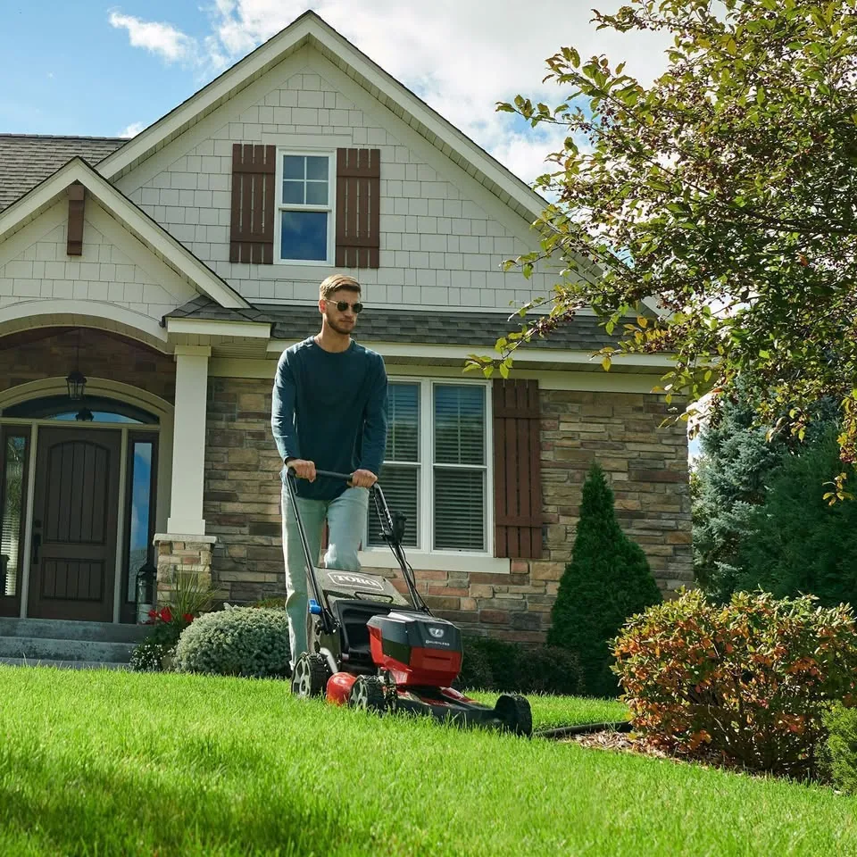 Red Toro walk-behind push mower at a home